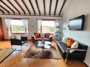 een woonkamer met banken en een flatscreen-tv bij Apartamento de la Villa I in Villa de Leyva