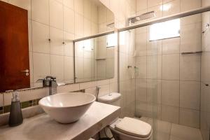 a bathroom with a sink and a toilet and a mirror at Recanto das Araras in Pirenópolis +31 photos