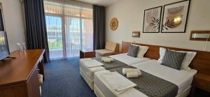 a hotel room with a bed and a desk at Hotel Liani - All Inclusive in Sunny Beach