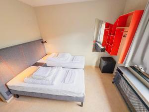 two beds in a small room with red cabinets at Dalur - HI Eco Hostel in Reykjavík +81 photos