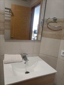 Un baño con un lavabo blanco y un espejo. en Buena Vista, en Arinaga