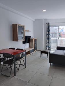 una sala de estar con una mesa y un sofá en Buena Vista, en Arinaga