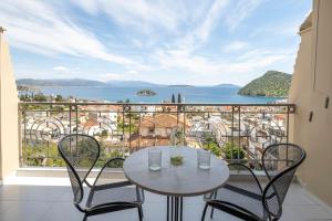 Una mesa y sillas en un balcón con vista al mar. en ELIXIA, en Tolo