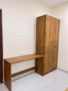 a wooden cabinet in the corner of a room at Ram Residency chengalpattu in Ottivākkam