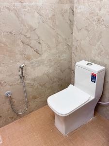 a white toilet in a bathroom with a shower at Ram Residency chengalpattu in Ottivākkam