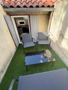 an overhead view of a balcony with chairs and a table at Appartement rénové en centre-ville avec terrasse in Millau