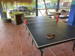 un tavolo da ping pong con una pagaia sopra di Mangomar Beach House a Teotepeque