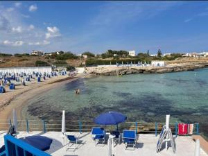 a beach with chairs and umbrellas and people in the water at Meraviglioso in Cozze