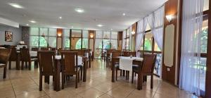 a restaurant with wooden tables and chairs and windows at Hotel Liani - All Inclusive in Sunny Beach