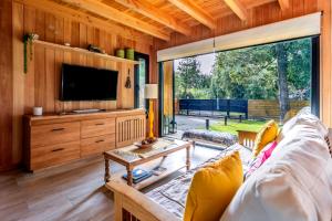 Una sala de estar con un sofá y un televisor. en BOG Cherry House, en Villa La Angostura