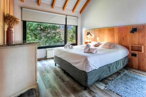 Un dormitorio con una cama grande y una ventana grande. en BOG Cherry House, en Villa La Angostura