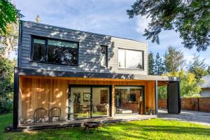 Una casa moderna con techo y ventanas negras. en BOG Cherry House, en Villa La Angostura