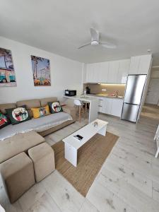 ein Wohnzimmer mit Couch und Küche in der Unterkunft Dinas KOKA Resort in Playa del Ingles