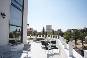 a balcony with a table and chairs on a building at Armada Avenue Hotel Amman in Amman