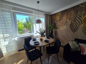 a dining room with a table and chairs and a window at Apartamenty Słoneczna in Sława