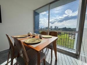 a dining room table with chairs and a large window at Monteazul1206- Lindo y amplio apartamento con piscina gym in Armenia