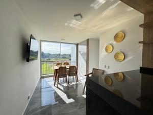 a dining room with a table and a large window at Monteazul1206- Lindo y amplio apartamento con piscina gym in Armenia