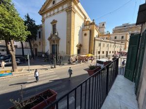 two people walking down a street in front of a building at HrD Luxury Rooms in Palermo