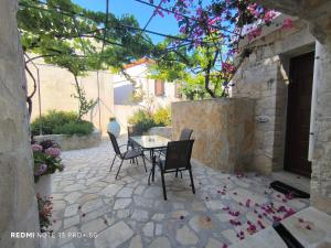 a patio with a table and chairs and flowers at Poseidon Apartments in Gaios