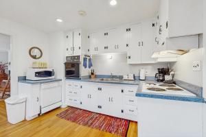 a kitchen with white cabinets and a counter top at Vineyard Charm in Edgartown