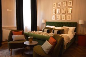 a bedroom with a green bed with a couch and chairs at Historic manoir in Vire Normandy elegance in a semi-rural setting ideal for groups and families in Vire