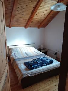 a bed in a room with a wooden ceiling at Apartman Lucija in Žabljak