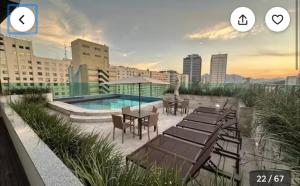 里约热内卢Studio com piscina no Casa Mauá的带桌椅的露台和游泳池