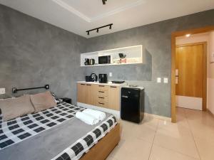 里约热内卢Studio com piscina no Casa Mauá的一间带床的卧室和一间小厨房