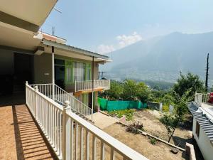 a house with a balcony with a view of a mountain at The Royals stays in Manāli