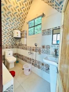 a bathroom with a sink and a toilet at The Royals stays in Manāli