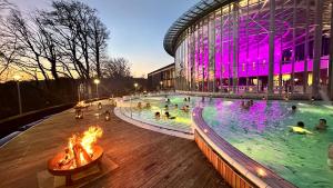a swimming pool in front of a building with people in it at Le P'tit Padré in Jalhay
