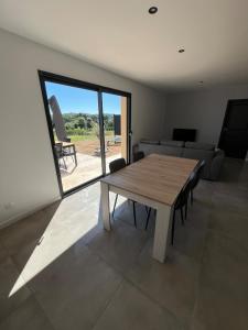 un soggiorno con un tavolo di legno e un divano di Maison Neuve Climatisée a Carlux