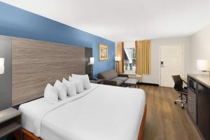 a hotel room with a large white bed and a desk at Baymont by Wyndham Richburg - Chester Area in Richburg +26 photos