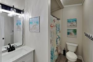 a bathroom with a toilet and a sink and a mirror at Island Club #104 in Put-in-Bay +34 photos
