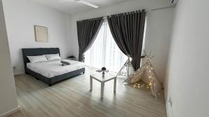 a bedroom with a bed and a table in front of a window at Comfy Terrace House Homestay near Zoo with Netflix in Taiping