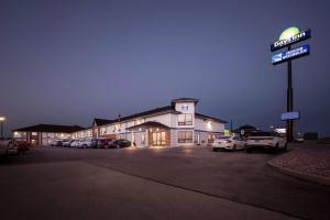 un edificio con un cartel en un estacionamiento en Days Inn by Wyndham Mitchell SD, en Mitchell