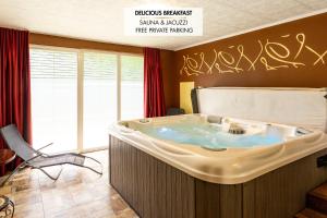 PrevaljeGuest House Hober的墙上有涂鸦的房间里的热水浴缸