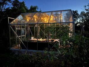 a glass greenhouse in a garden at night at Bockekulla Gård in Bergkvara