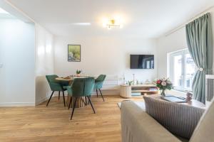 a living room with a table and green chairs at Les toits d'Angoulême in Angoulême