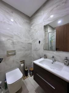 un bagno con un water bianco e un lavandino di Appartement moderne avec piscine, 2 chambres a Bouznika
