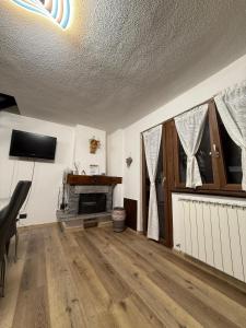 sala de estar con TV y chimenea en Petit Maison - Valtournenche, en Valtournenche