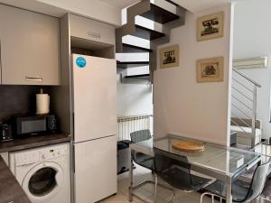 a kitchen with a washing machine and a glass table at Lujoso Loft La Moraleja in Madrid