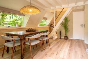 een eetkamer met een houten tafel en stoelen bij Boshuisje Rekem - Kitoko in Lanaken