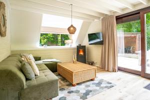 een woonkamer met een bank en een tafel bij Boshuisje Rekem - Kitoko in Lanaken