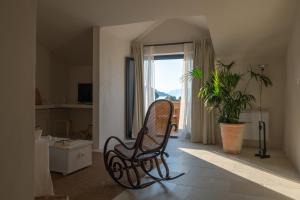 a rocking chair in a room with a window at Almarìa - Le case del Castello - San Nicola L'Arena - Trabia in Trabia