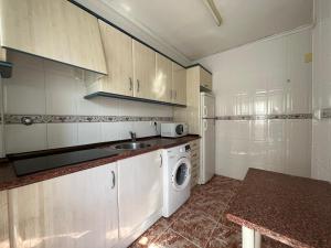 a kitchen with a sink and a washing machine at Casablanca in Miramar +9 photos