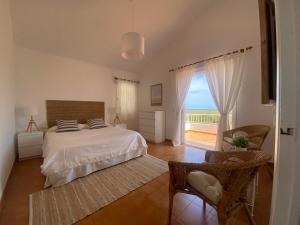 a bedroom with a bed and a view of the ocean at Menorca Villa Fenicia in Son Parc