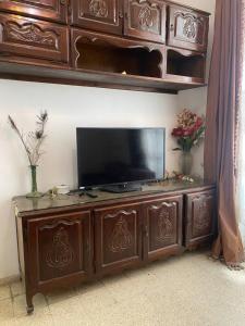 a wooden entertainment center with a flat screen tv on it at Tunis centre ville in Tunis