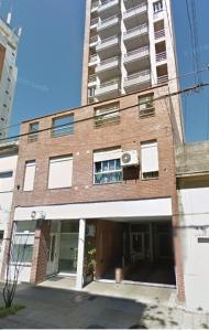 a tall brick building with a large building at departamento 4 y 59 in La Plata