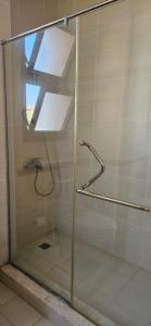 una ducha con puerta de cristal en un baño en Marassi Villa Twinhouse, en El Alamein 16 fotos más